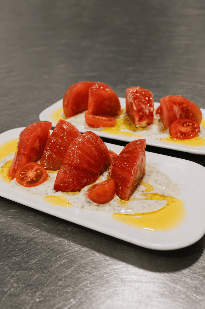 Ensalada de tomate Barbastro con tomate amarillo sobre salsa de yogurt, pepino y albahaca